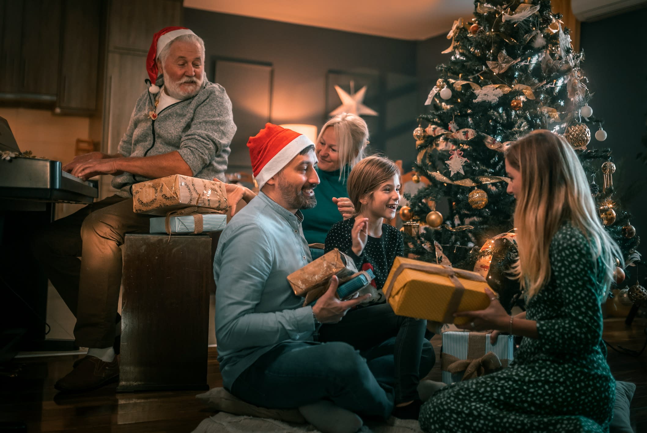 Multigeneration family on the living room exchanging Christmas presents.