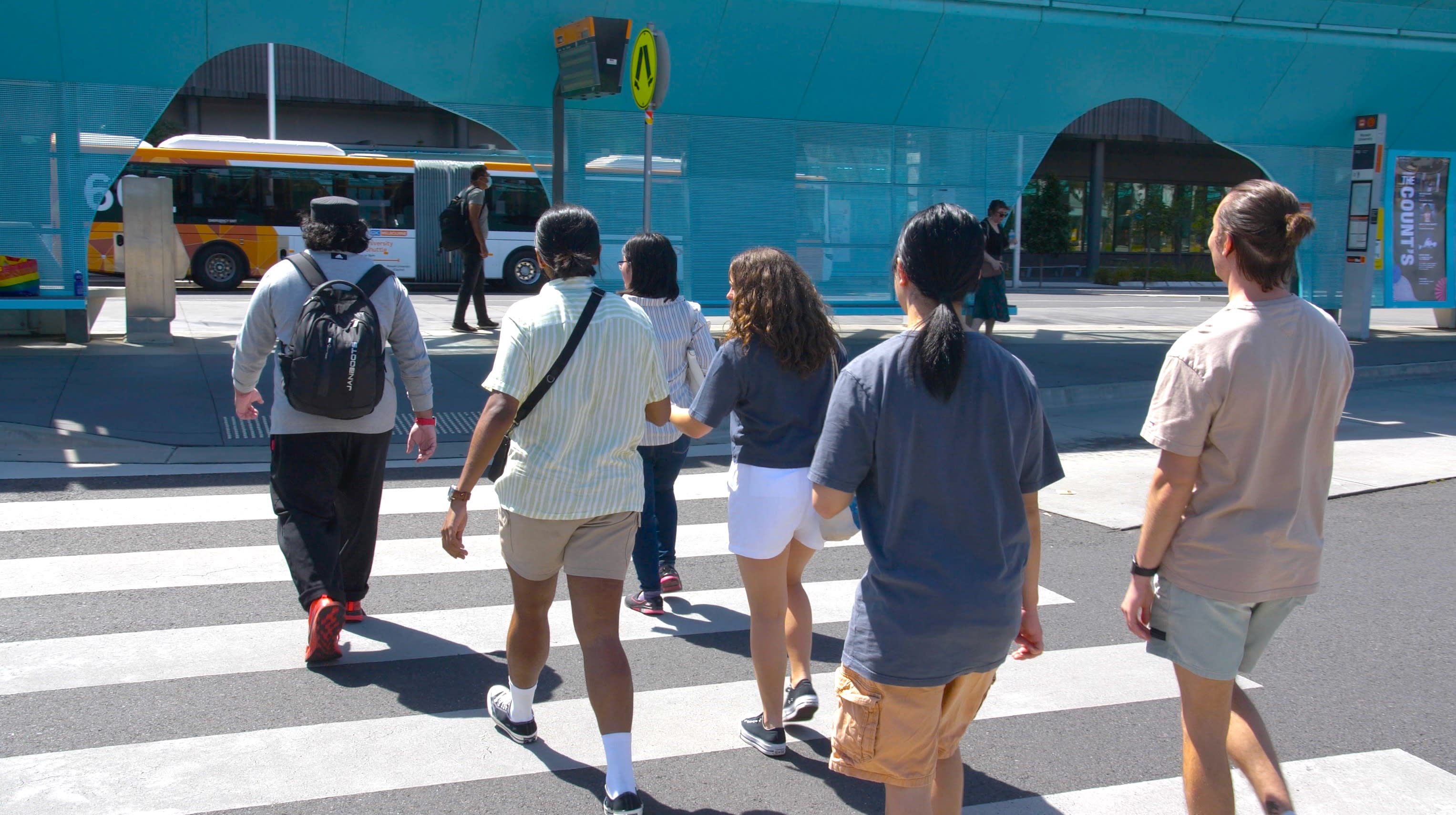 Students walk across a zebra crossing on their way to Monash University campus.