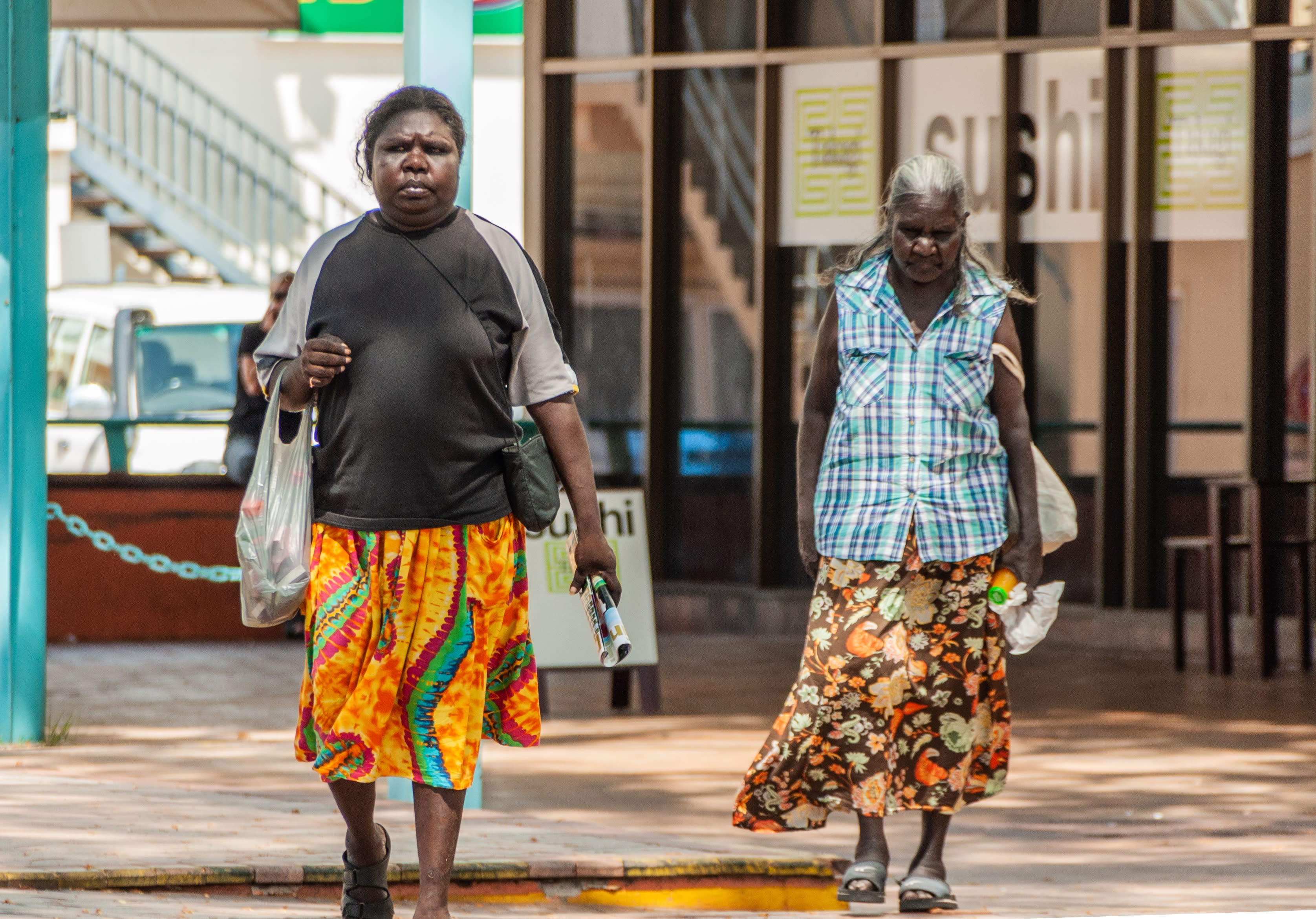 Two Indigenous women walk down the street in the Northern Territory's capital Darwin.