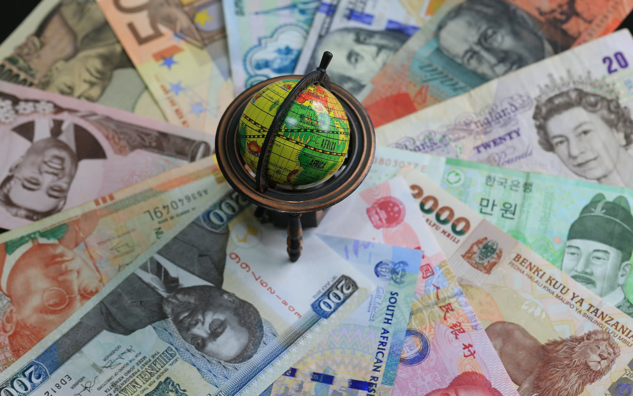 World currencies spread around a globe.