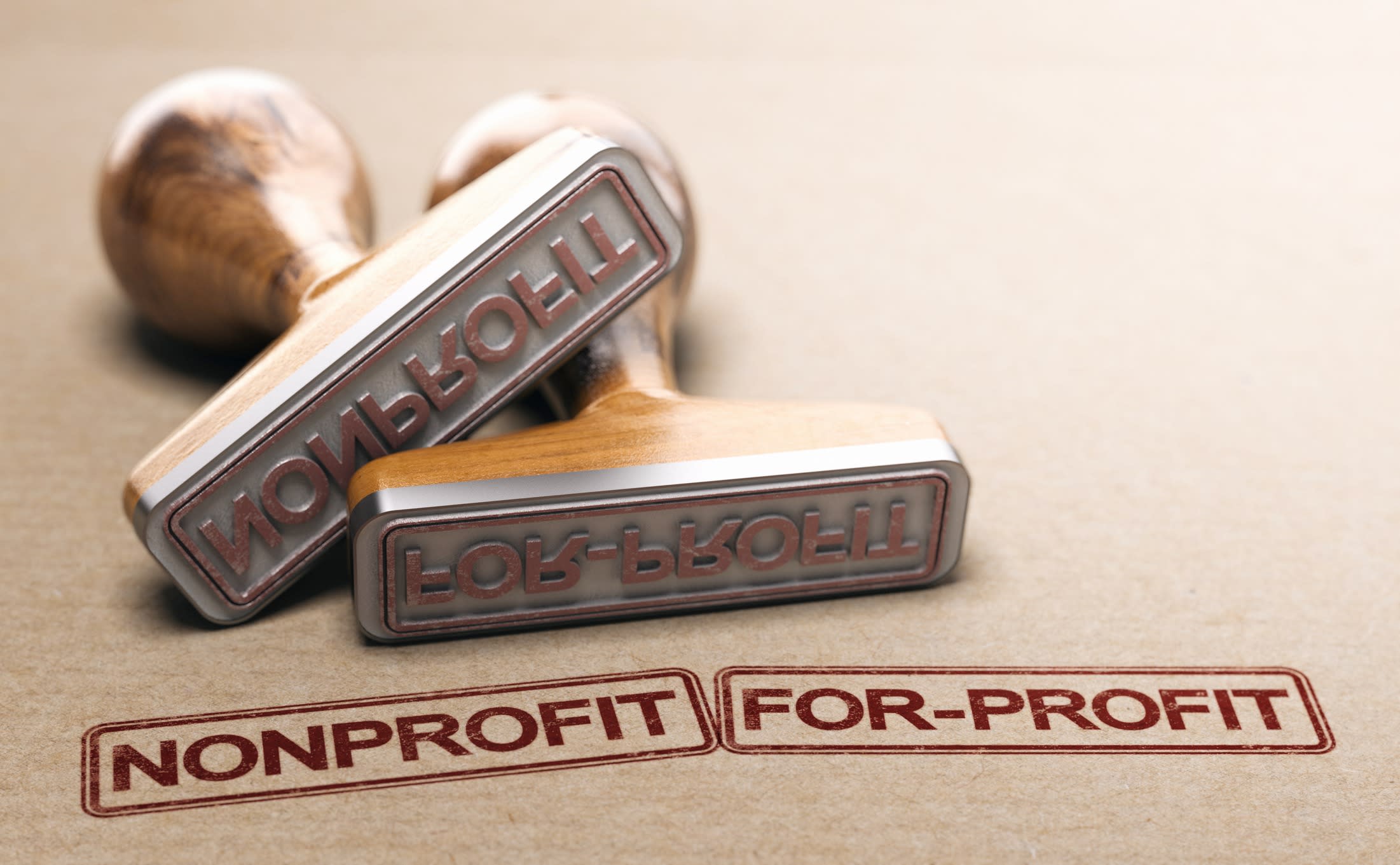 Nonprofit and for-profit printed on paper background with two rubber stamps