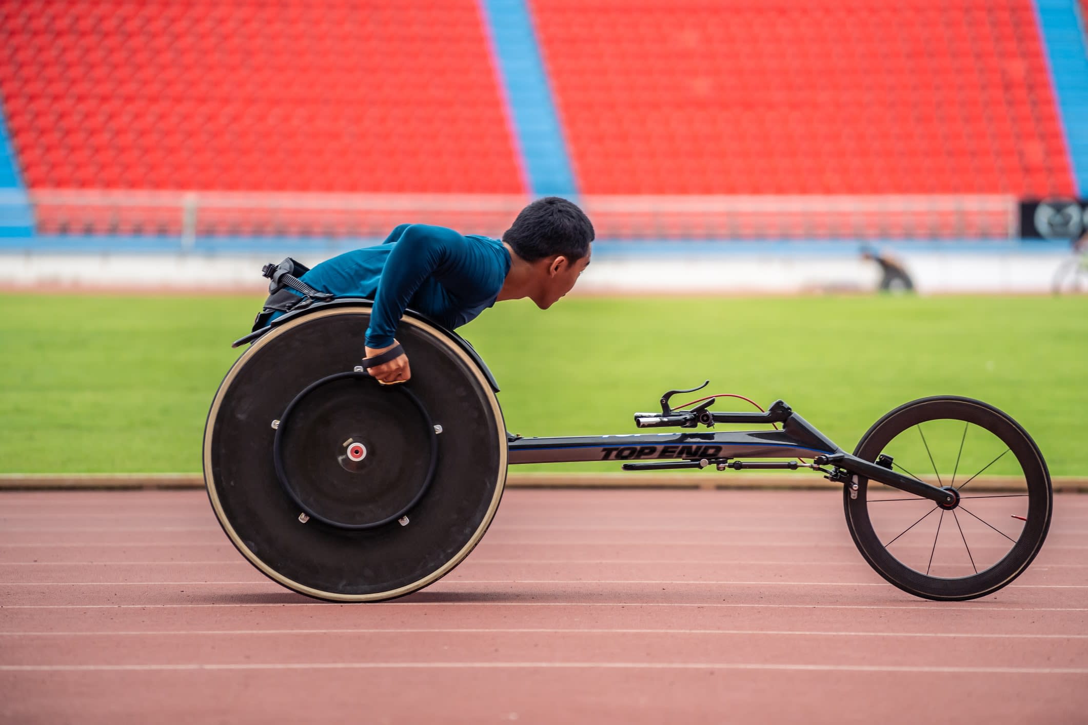 A male para-athlete in a racing wheelchair on an athletics track