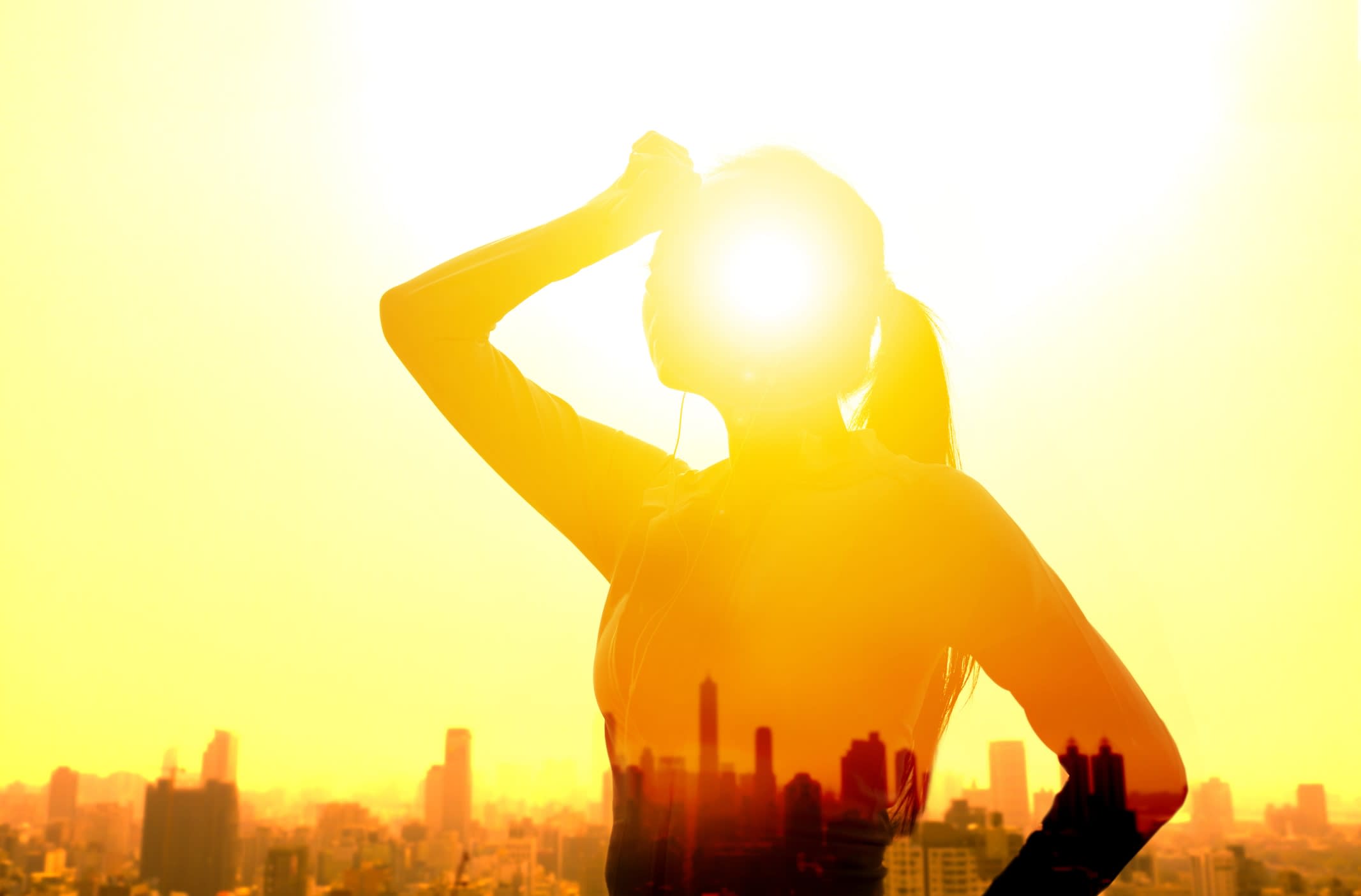 Double exposure portrait of a young woman, hand wiping sweat, in summer heatwave concept