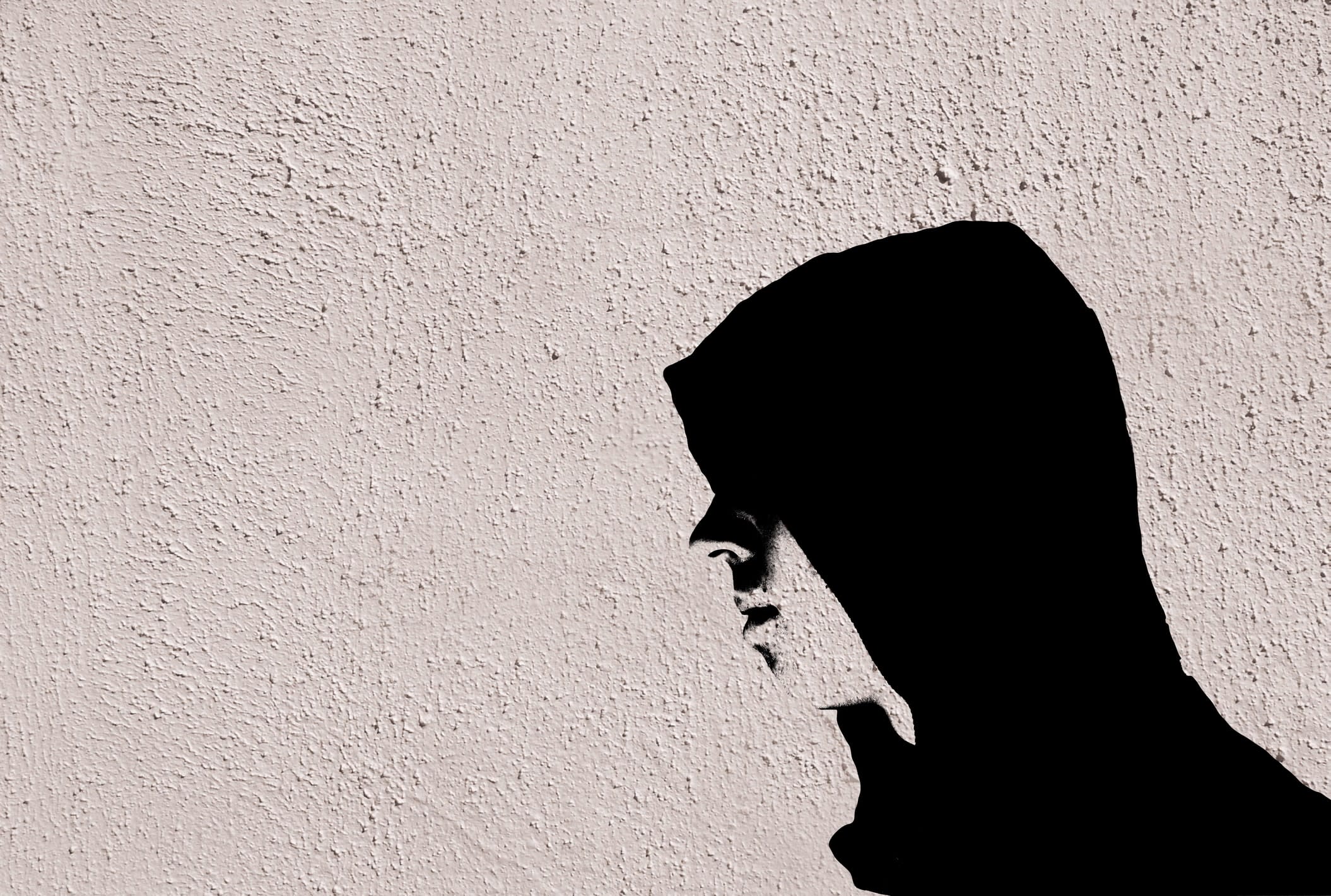 Stencil art of a teenage boy in black hoodie in profile 