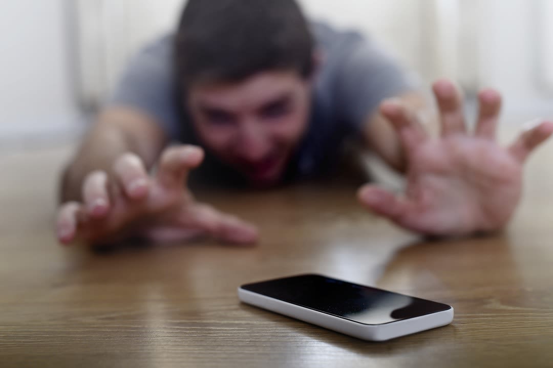 Un Homme Allongé Sur Le Sol Cherche Désespérément Son Téléphone Portable.