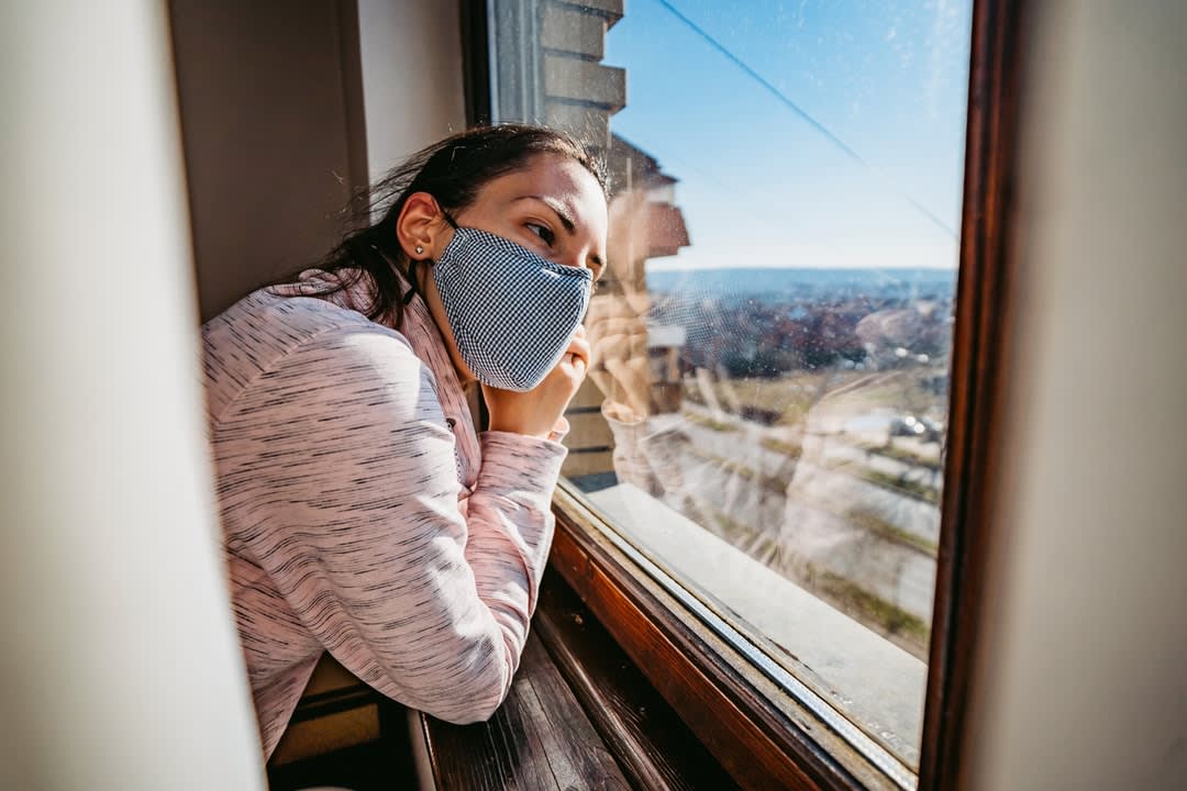 Woman in quarantine looking through the window