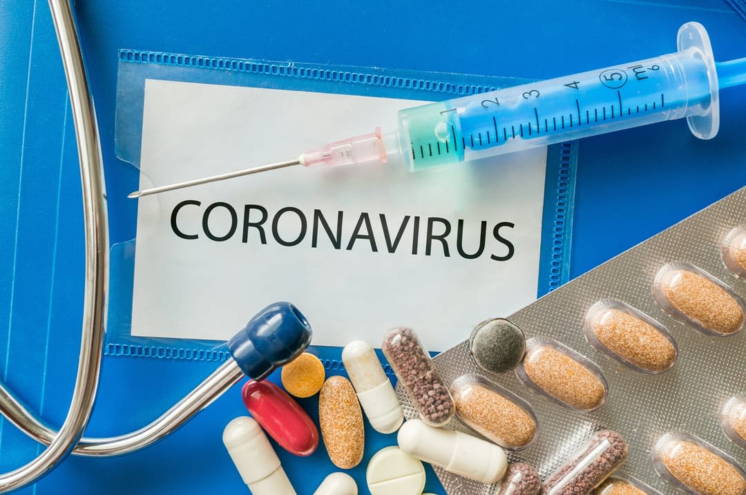 Novel coronavirus disease 2019-nCoV written on blue folder., with pills and a syringe