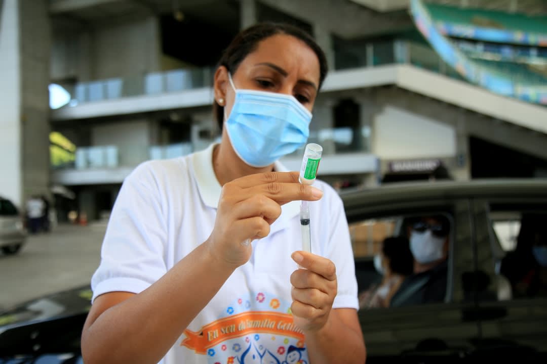 A woman prepares a COVID vaccine.