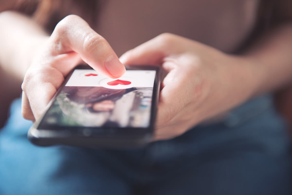 Close-up of hands holding a phone, using a dating app