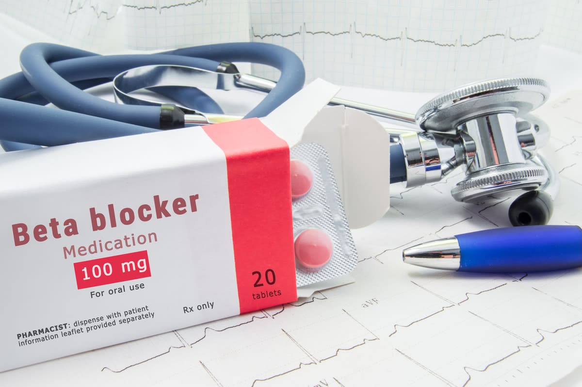 A pack of beta-blocker medication, a stethoscope and a pen, on top of a ECG printout