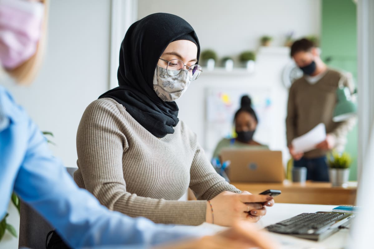 Ethnic employee in office with colleagues