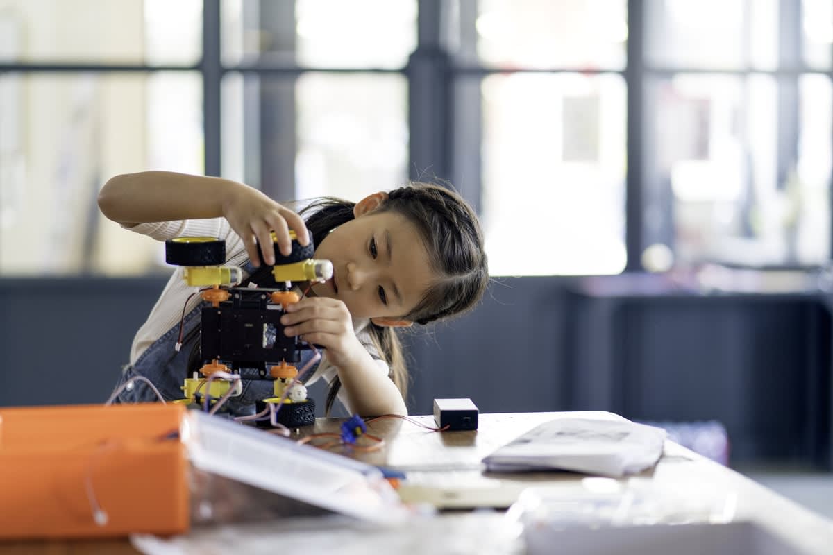 A young female student building a mechanical model