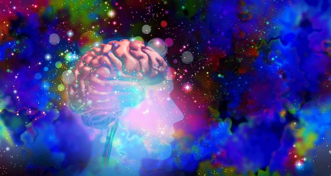 Illustration of a side silhouette of a see-through head, with the brain visible, surrounded by stars and multicoloured clouds