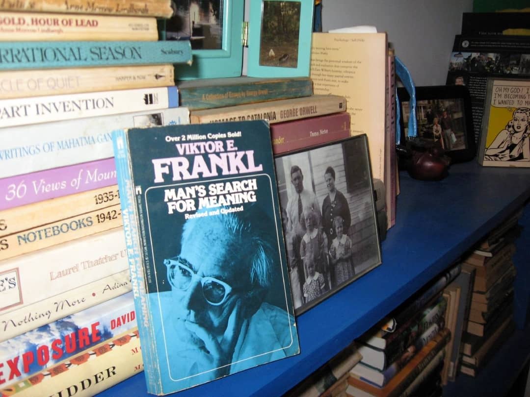 A stack of paperback books with Viktor Frankl's ‘Man's Search For Meaning‘ in the foreground