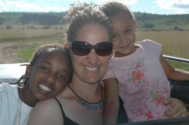 Smiling group shot of Jomo Kigotho’s cousin, Maureen (left), mother Ruth Rowlands, and younger sister Malaika, in Kenya.