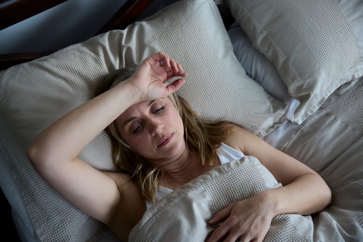 Mature Woman Suffering With Insomnia In Bed At Home