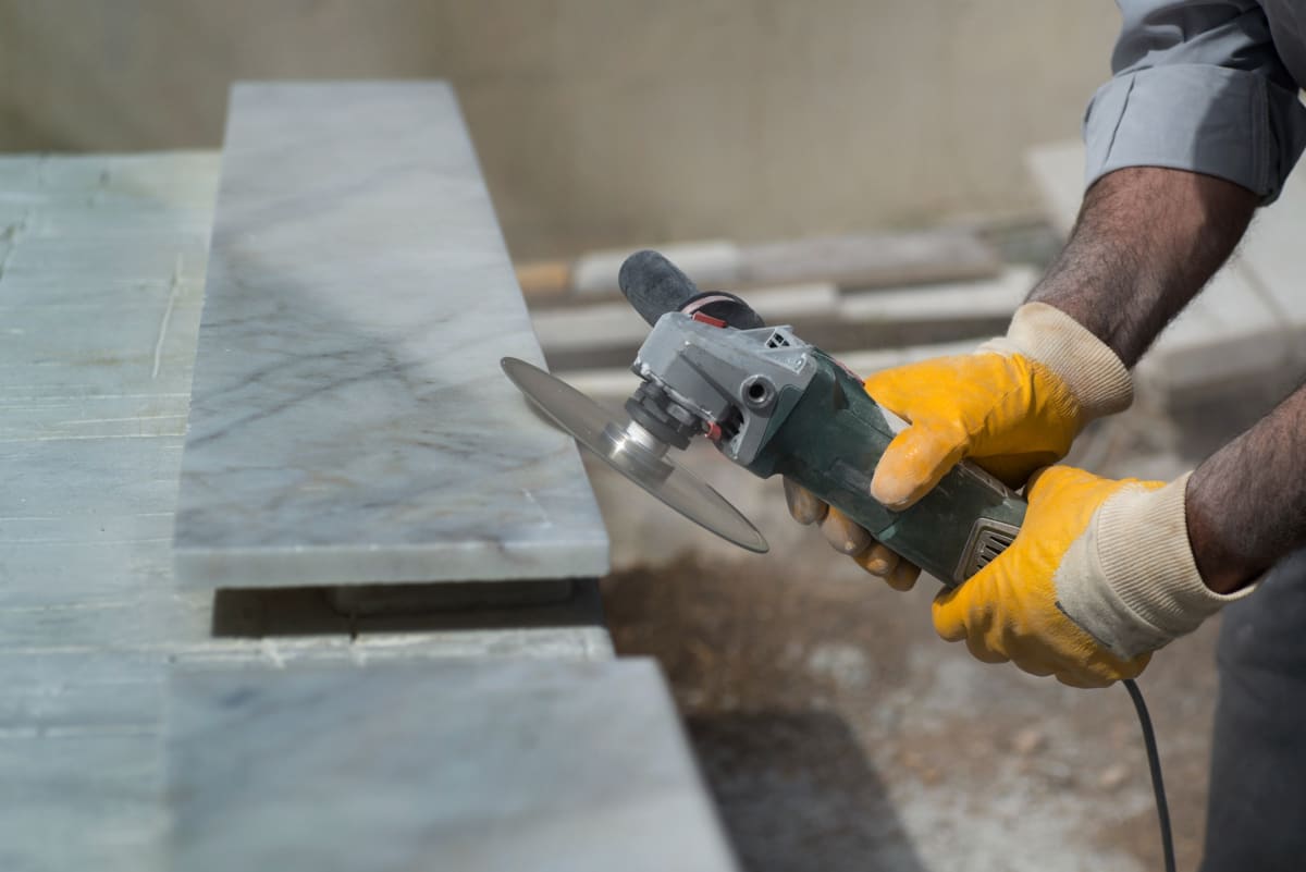 A worker cuts a stone benchtop.