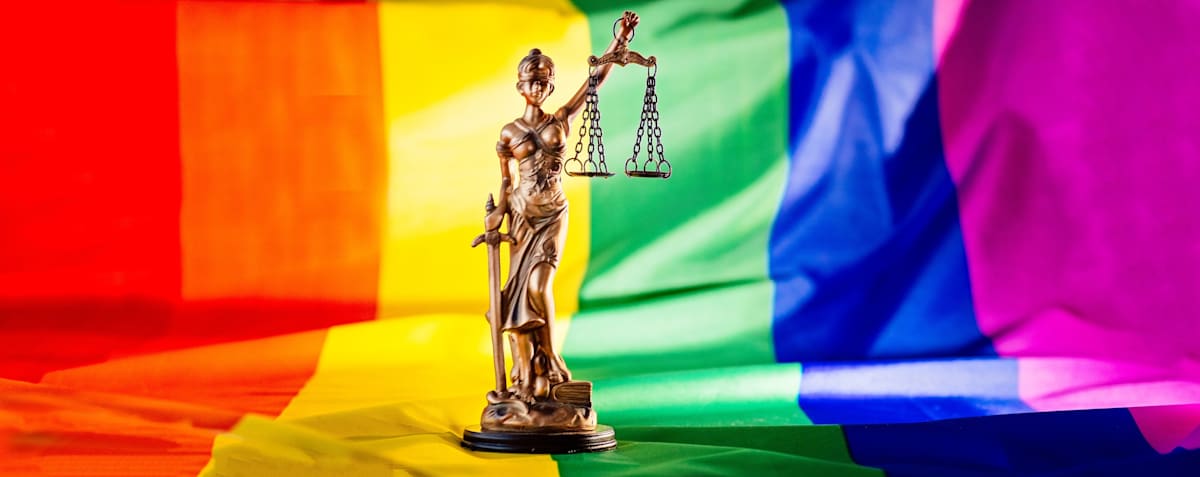 Scales of justice symbol of law and justice with LGBTIQA+ flag