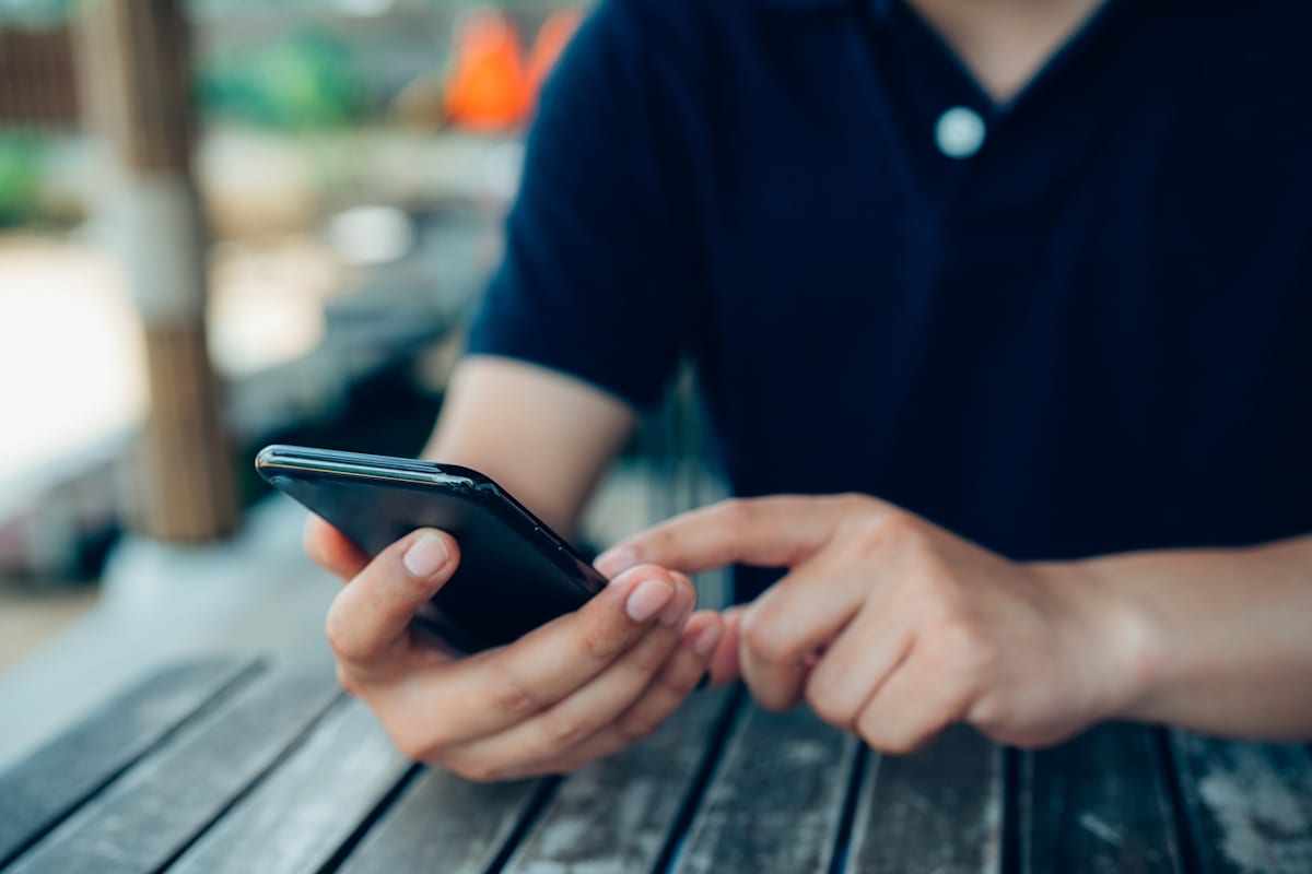 Close up of man hands with mobile phone. sitting at a table.