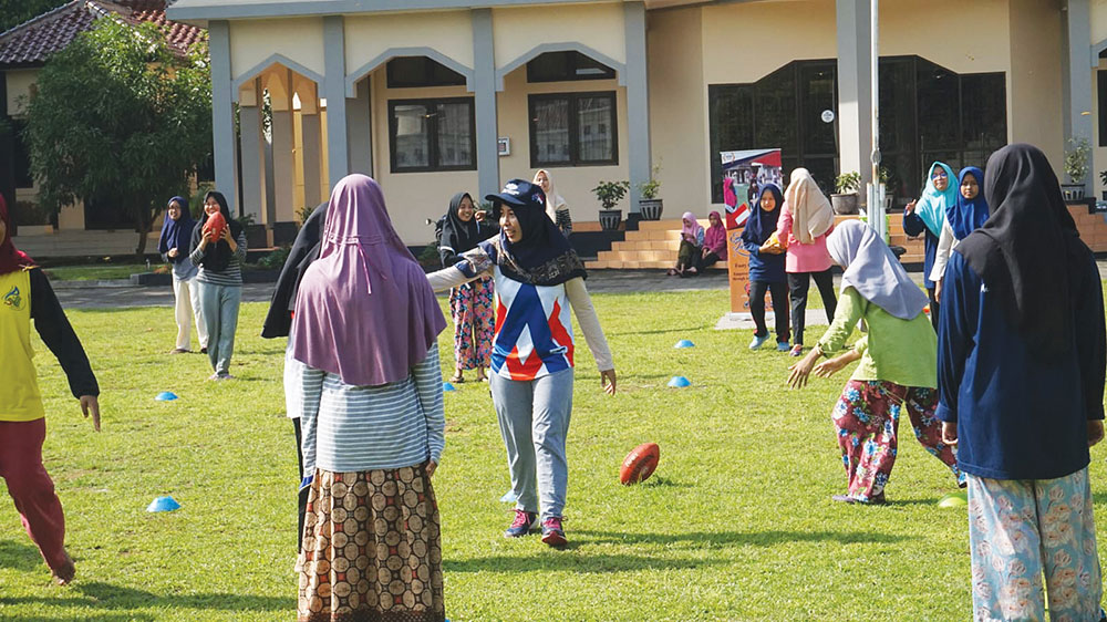 Ana is teaching her students in Indonesia how to play