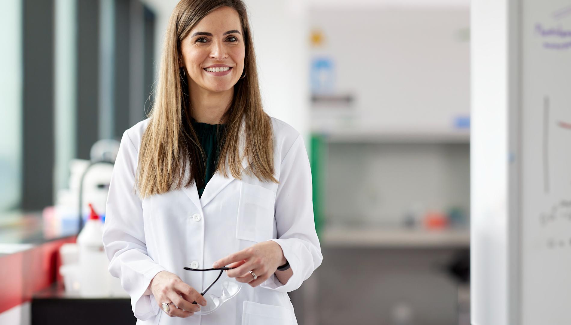 Francine Coelho Marques in her laboratory, wearing a white coat.