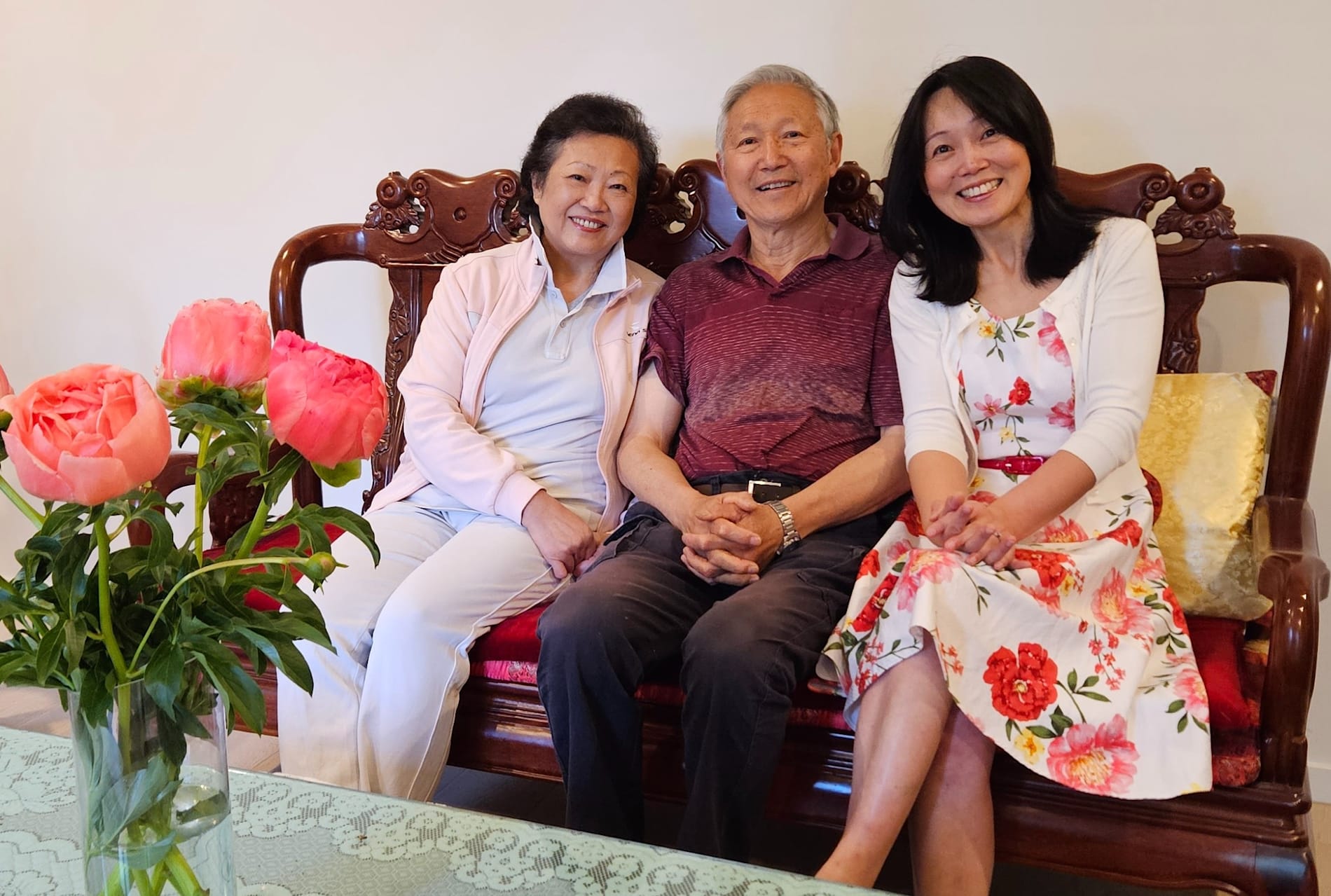 Monash University Associate Professor Jun Yang sits on a couch with her parents, her mother Cherrie Zhu and father Lisheng Yang.