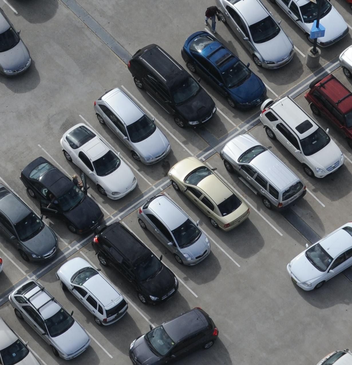 An aerial shot of a car park filled with cars.