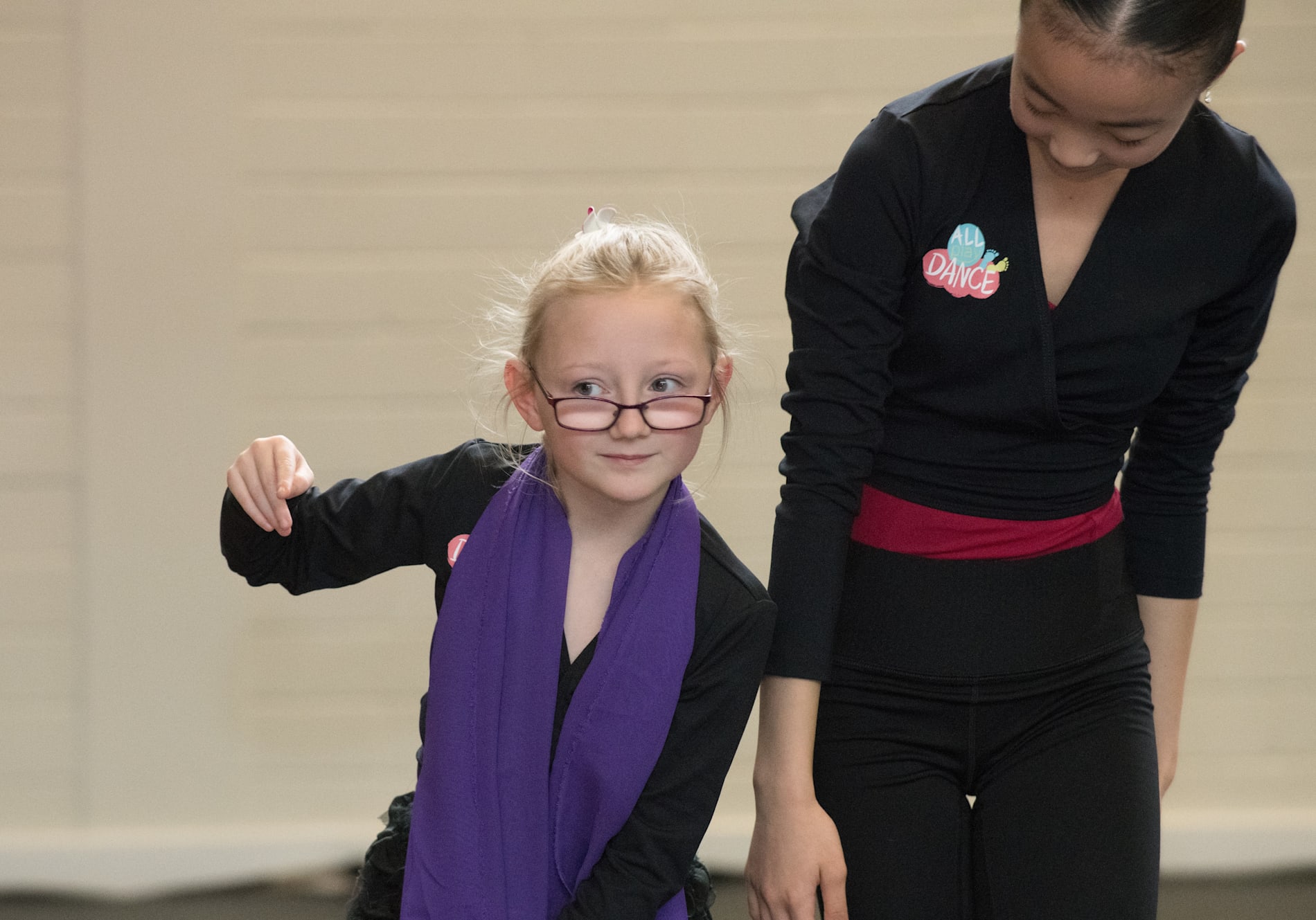 A young girl and dance teacher on a dance floor.
