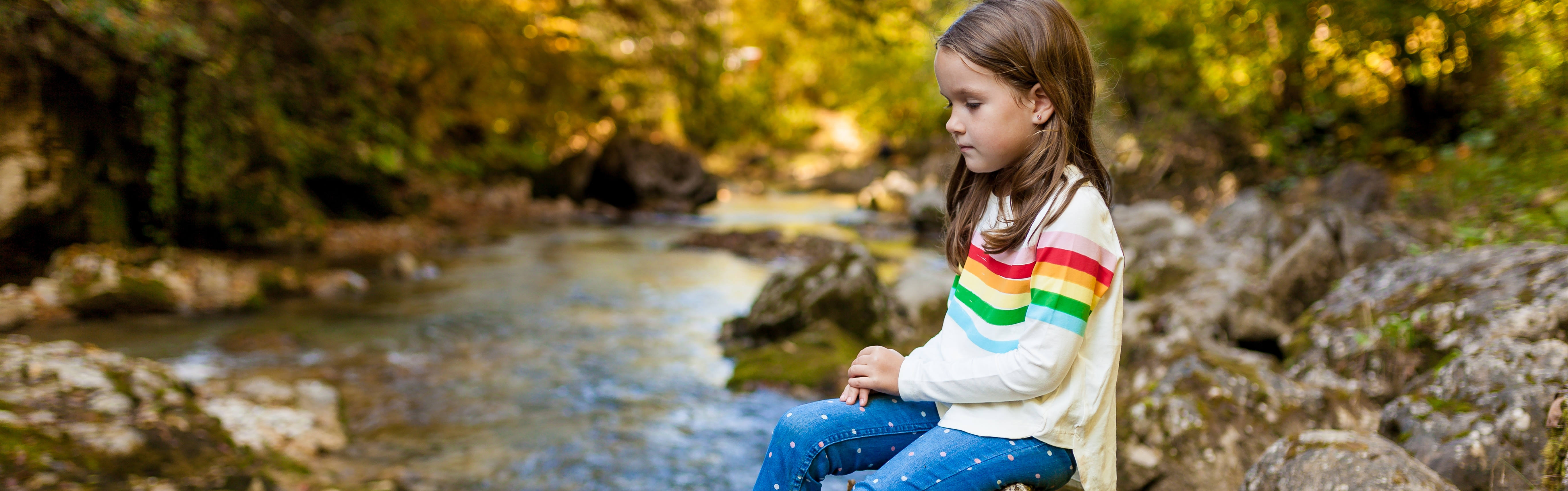 Girl by Stream in Fall