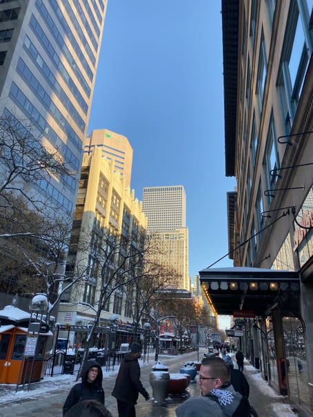 A view of downtown Denver on 16th Street with all the tall buildings and people walking around on a cold day after three days of snow.