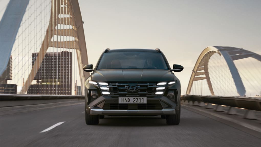 רכב נוסע על גשר ברקע יש בניינים. צילום מקדימה