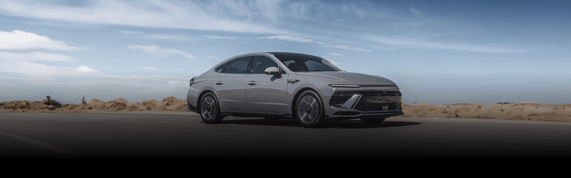 יונדאי סונטה בצבע לבן נוסעת על הכביש צילום מצד שמאל קדימה