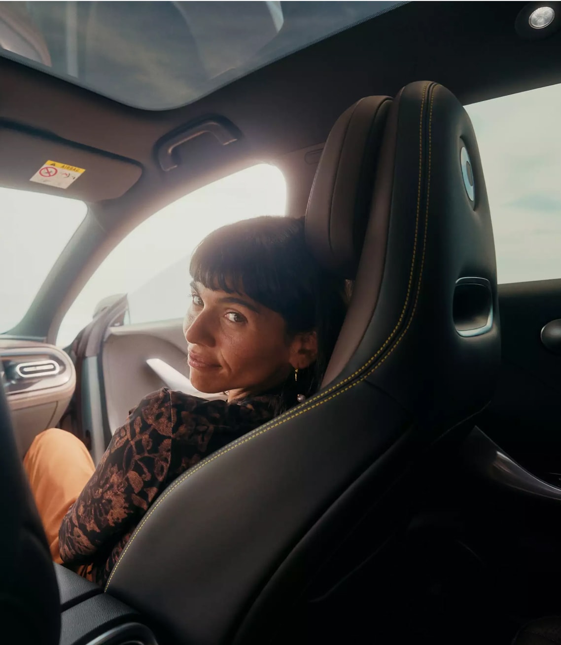 אישה מביטה אחורה מהמושב הקדמי