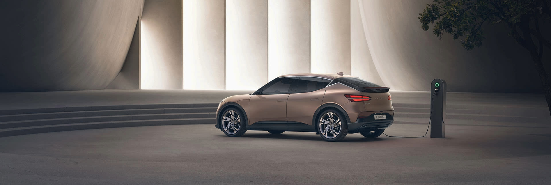 רכב חשמלי חונה ליד עמדת טעינה במתחם מודרני.