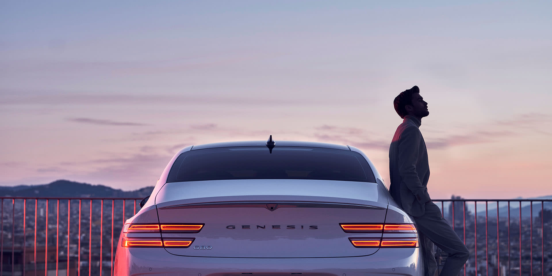 גבר נשען על רכב ג'נסיס חשמלי