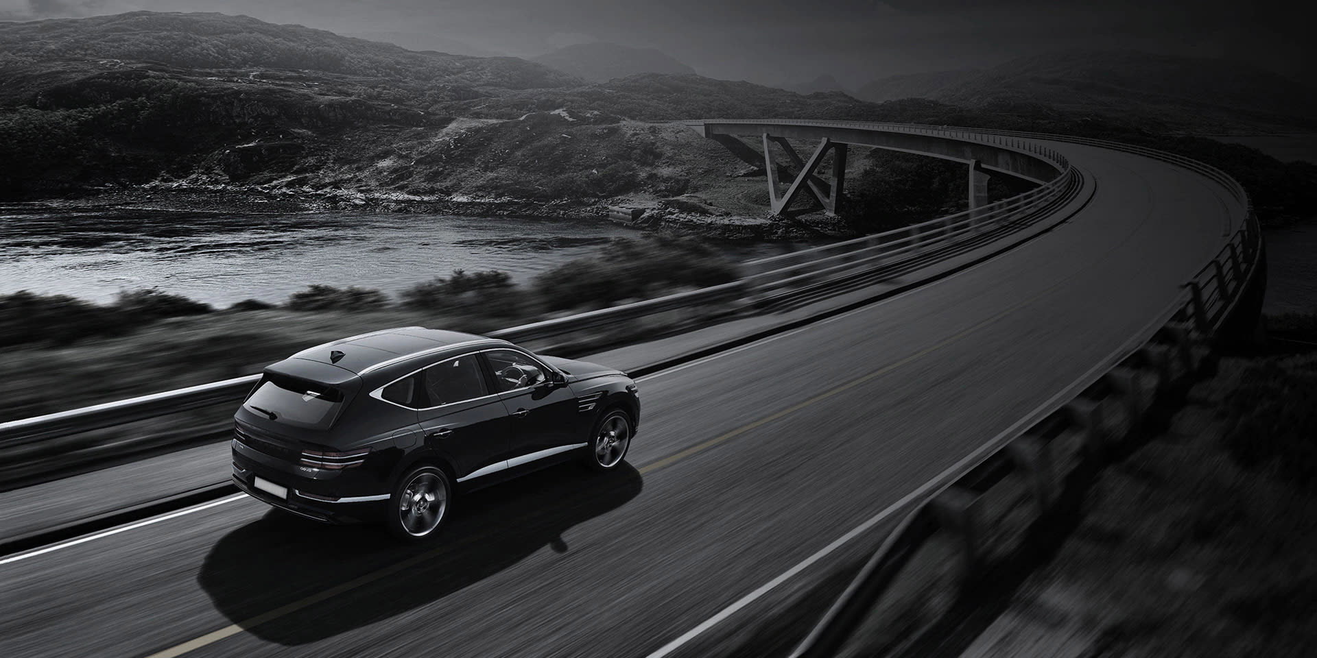 רכב שחור נוסע בכביש מהיר ליד נוף הררי.