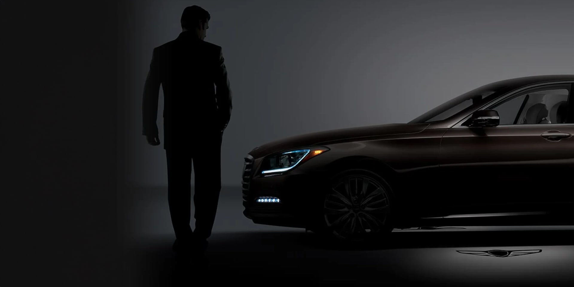 איש עומד לצד רכב יוקרה ג'נסיס