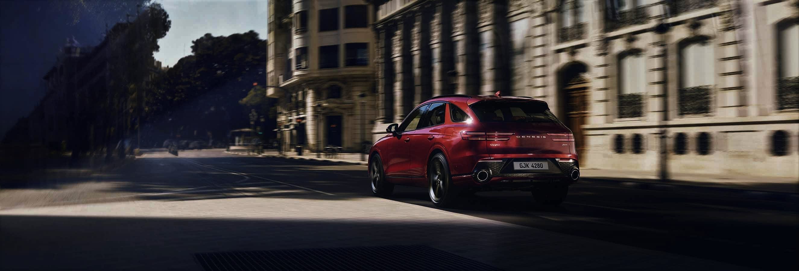 ג'נסיס GV70 בצבע אדום נוסעת בעיר בספרד - טרייד אין רכבי יוקרה
