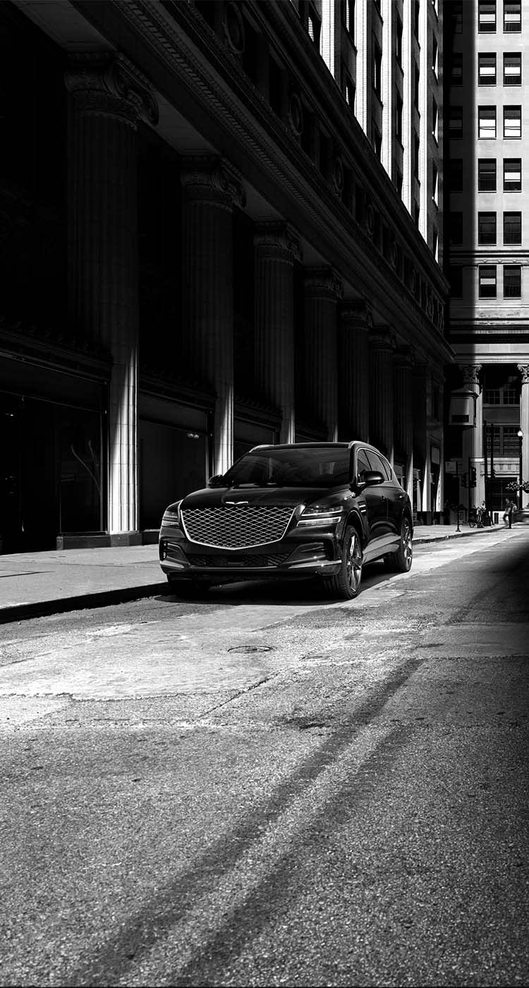 תמונה שחור לבן - ג'נסיס GV80 חונה לצד מדרכה עם ביטוח רכבי יוקרה מבית כלמוביל