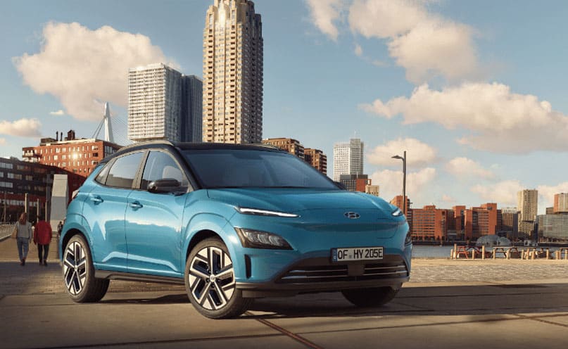 רכב יונדאי כחול על רקע העיר בשקיעה