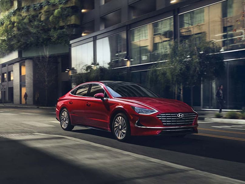 רכב היברידי בצבע אדום בזמן נסיעה