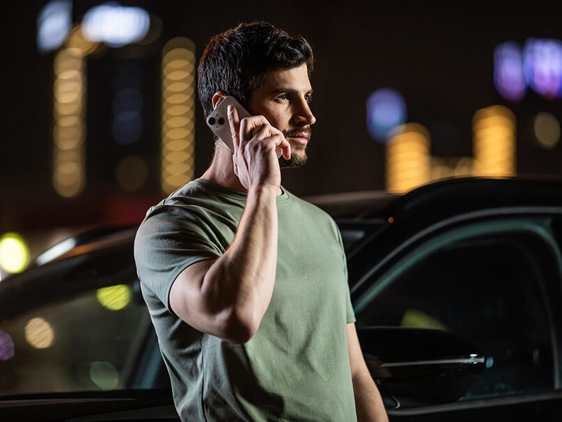 גבר מדבר בפלאפון לצידי רכב