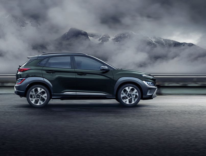 יונדאי טוסון 2022 כחולה נוסעת בנוף הררי במזג אוויר אפרורי