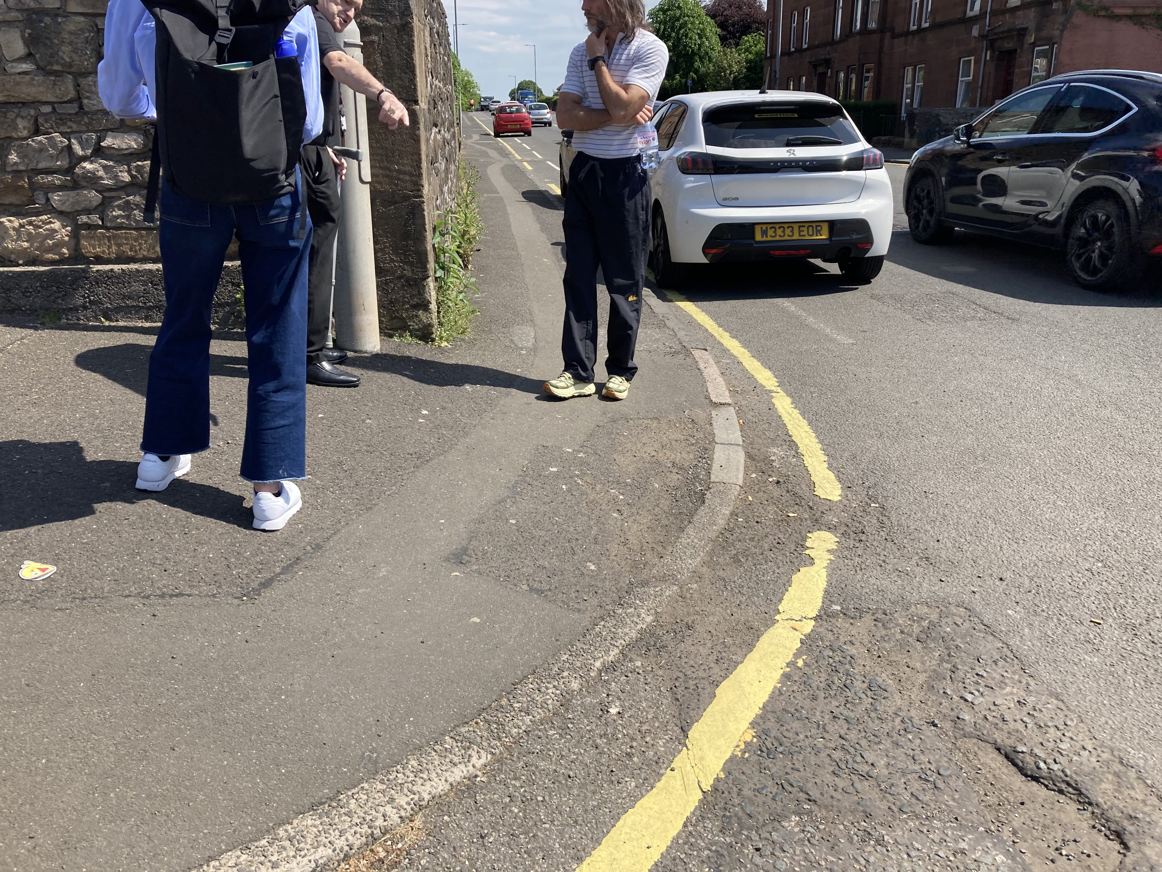 People standing in the street looking at dropped kerbs during a street accessibility audit