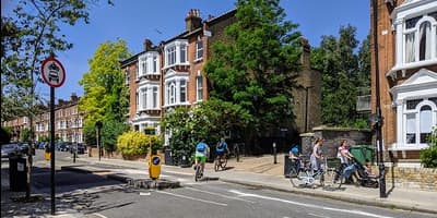 a street with a few people and bikes