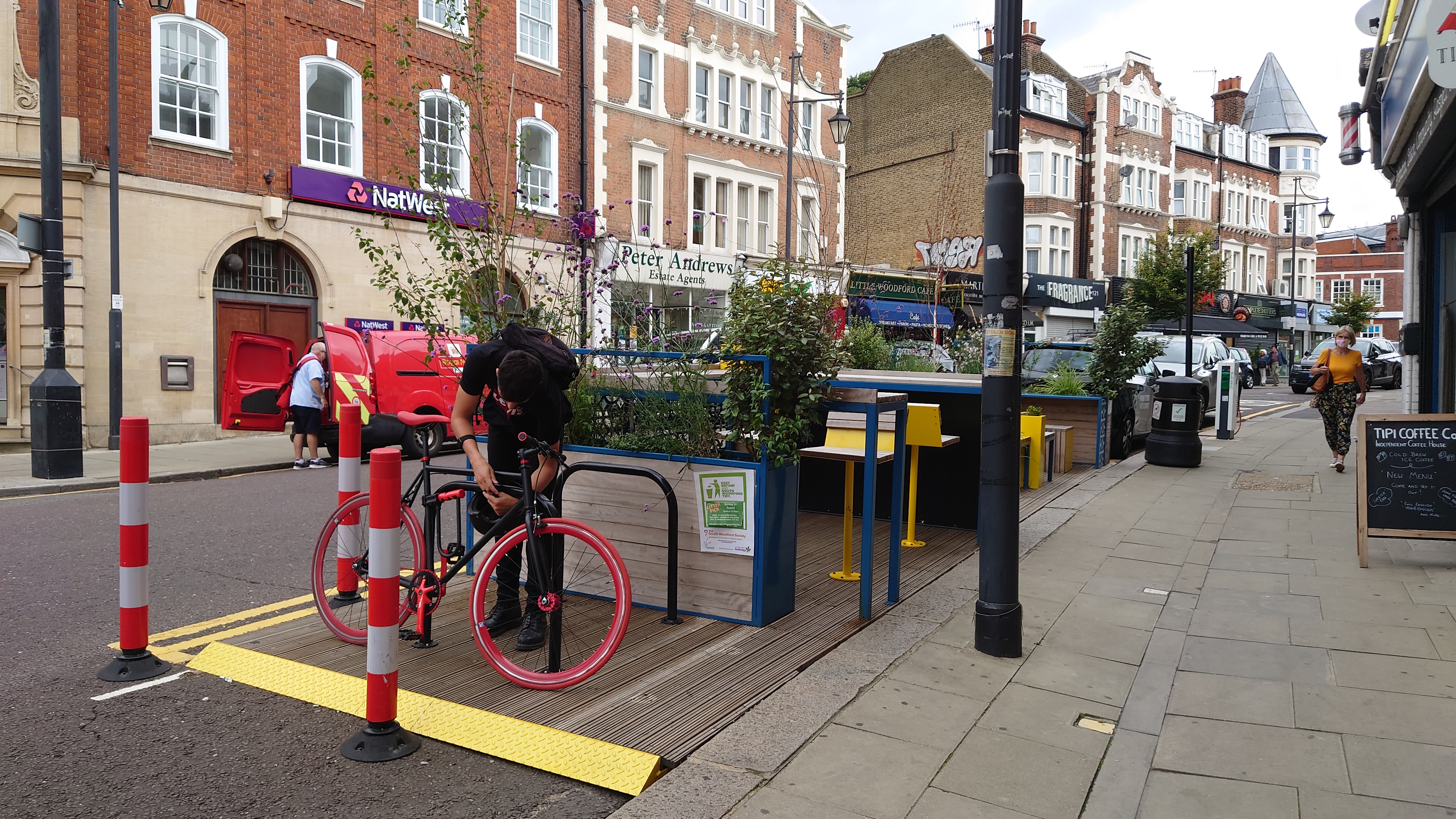 Someone locking their bike to a cycle parking stand that is part of the Mobility Hub.