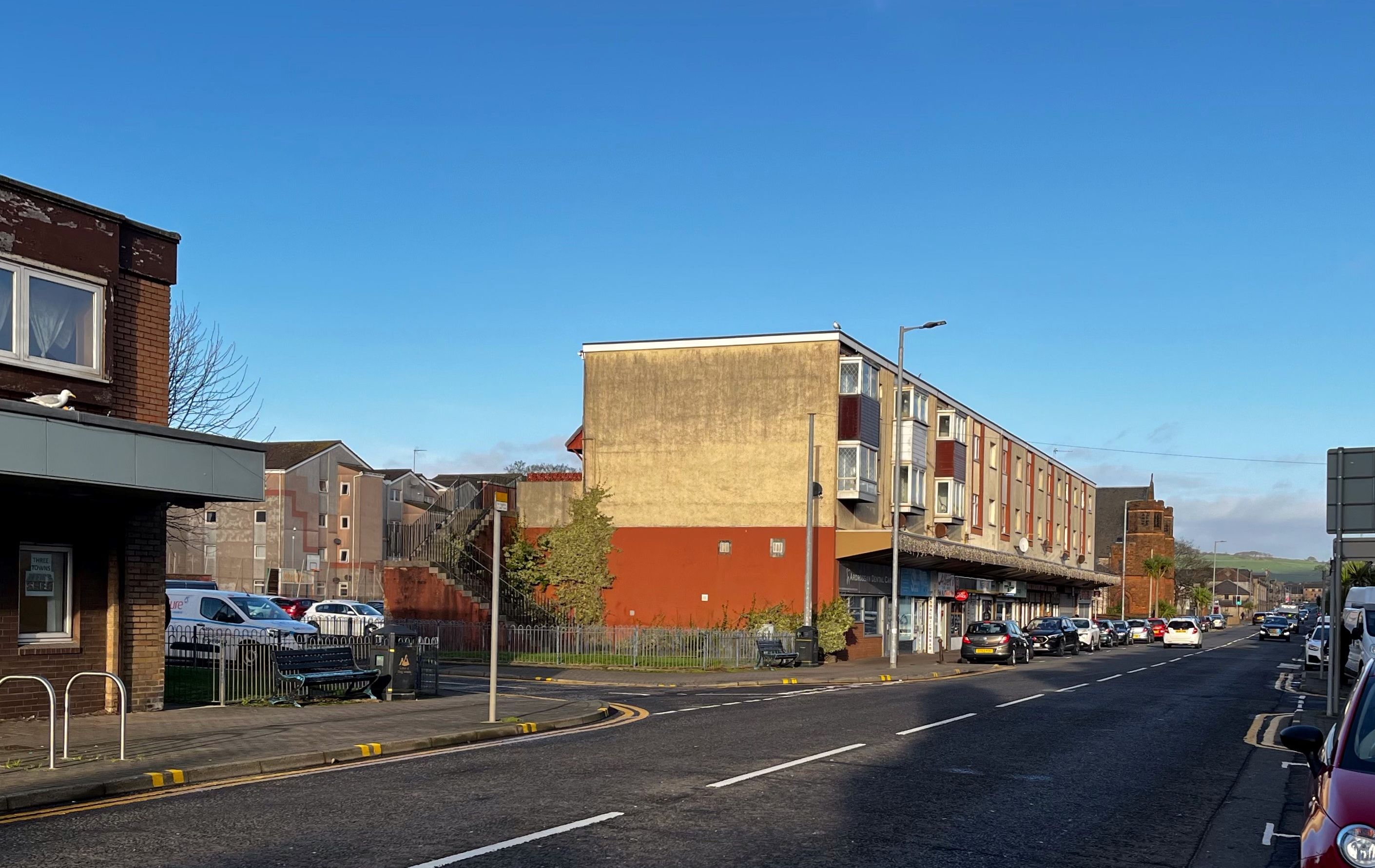 Image shows the greenspaces at the junction of Glasgow Street and Montgomerie Street, opposite Princes Place. The green spaces are currently fenced off, with a gate to enter them. 