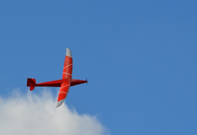 a red plane flying in the sky