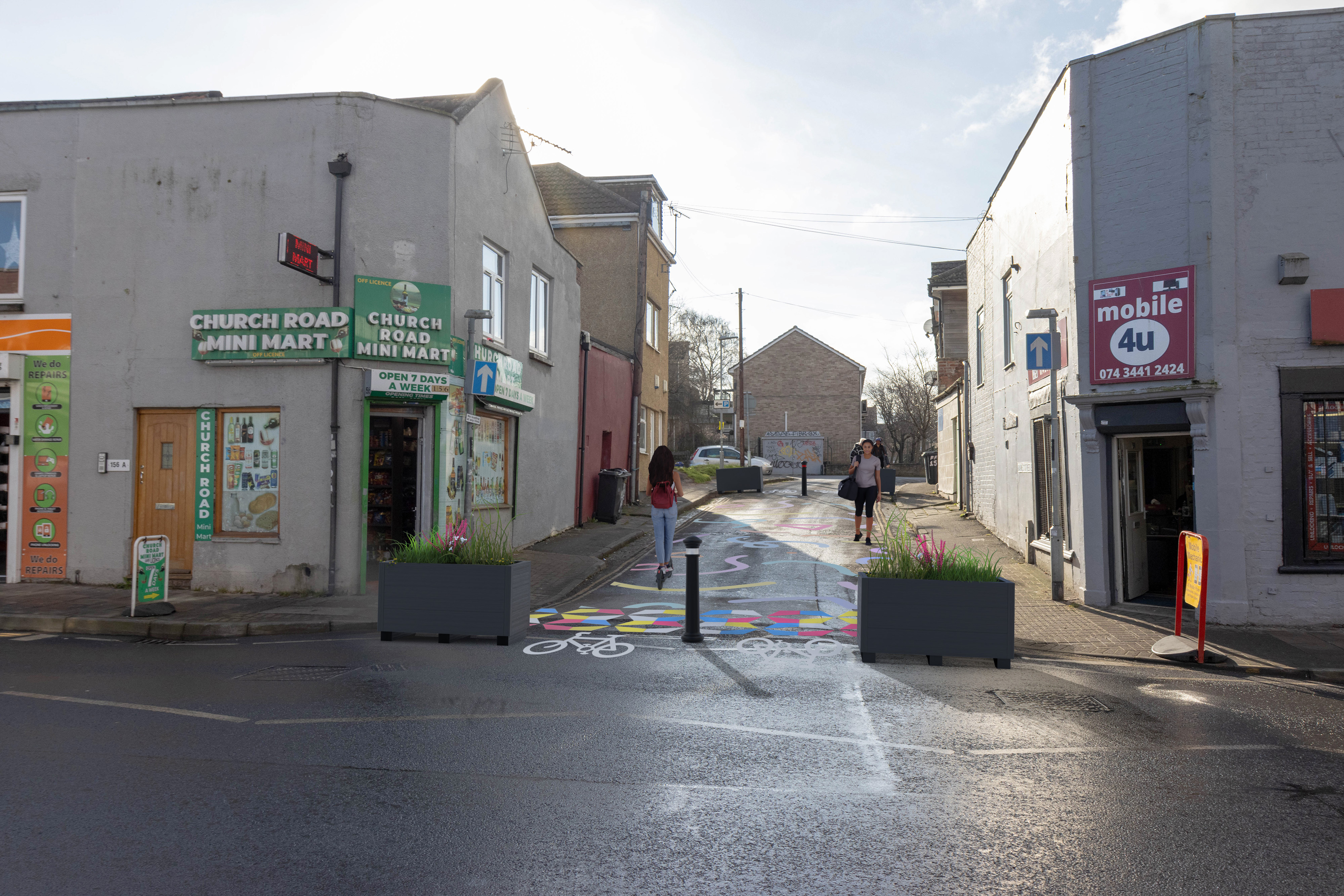 Planters and bollards at both ends of the street to stop vehicles moving through pedestrian area. Cyce symbols on the floor to show where bicycles will access. A loading bay is marked to help businesses with loading and unloading. 