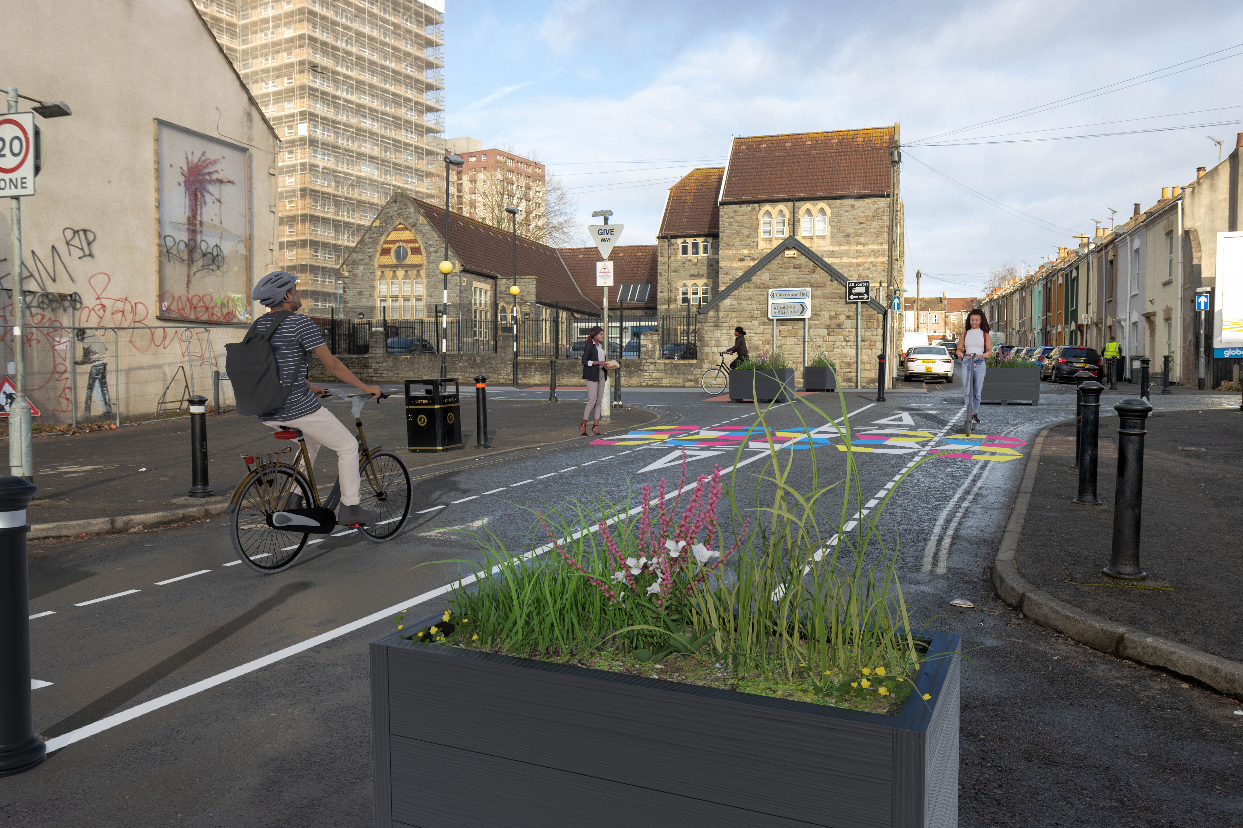 Planters and bollards used to stop vehicles passing through Marsh Lane. Cycle track marked through the middle with pedestrian crossing highlighted in colourful patterns. 